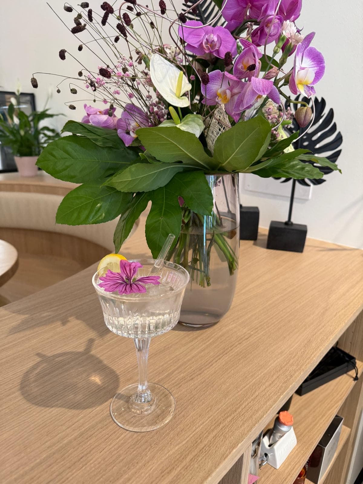 Foto von einem Drink im Hufschmiede Cafe mit einem Blumenstrauß dahinter